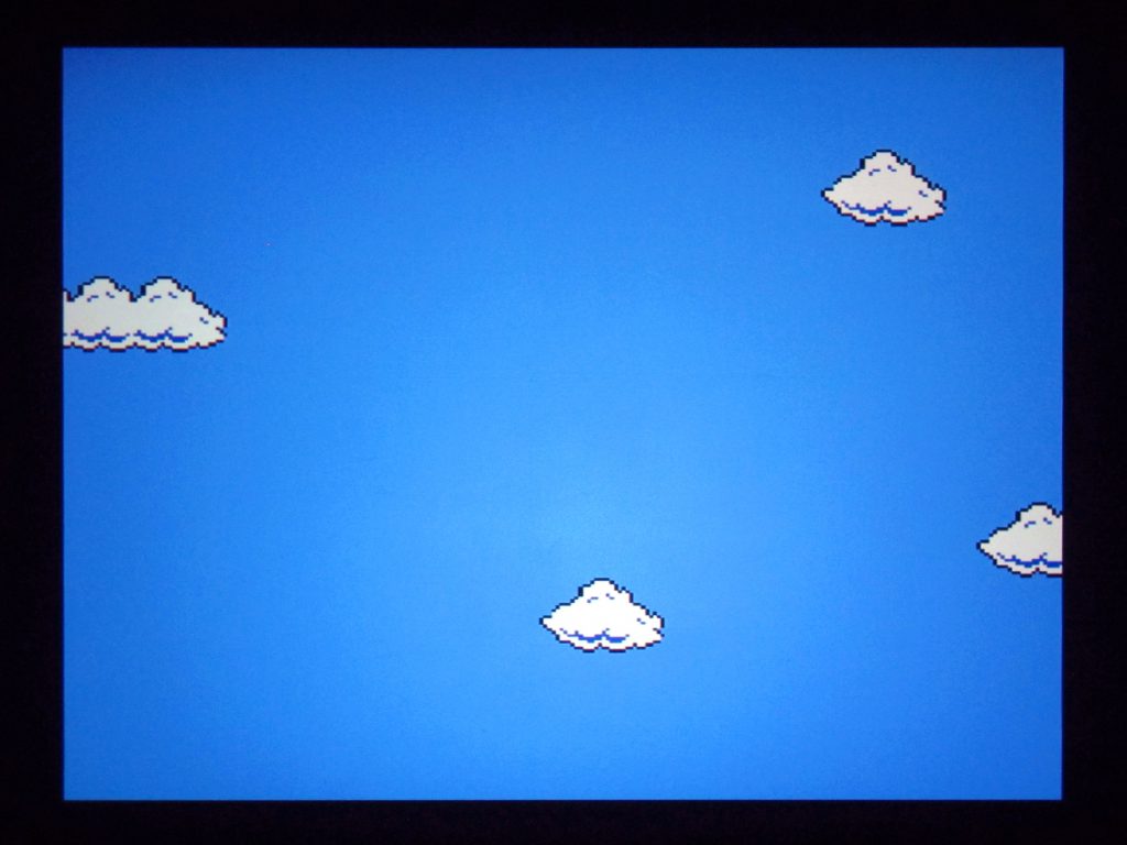 Fig. 6 Photograph of the projected image from Nestopia emulator. The clouds go all the way to the edges of the image. Photo: Emilie Magnin. Courtesy of the Migros Museum für Gegenwartskunst.